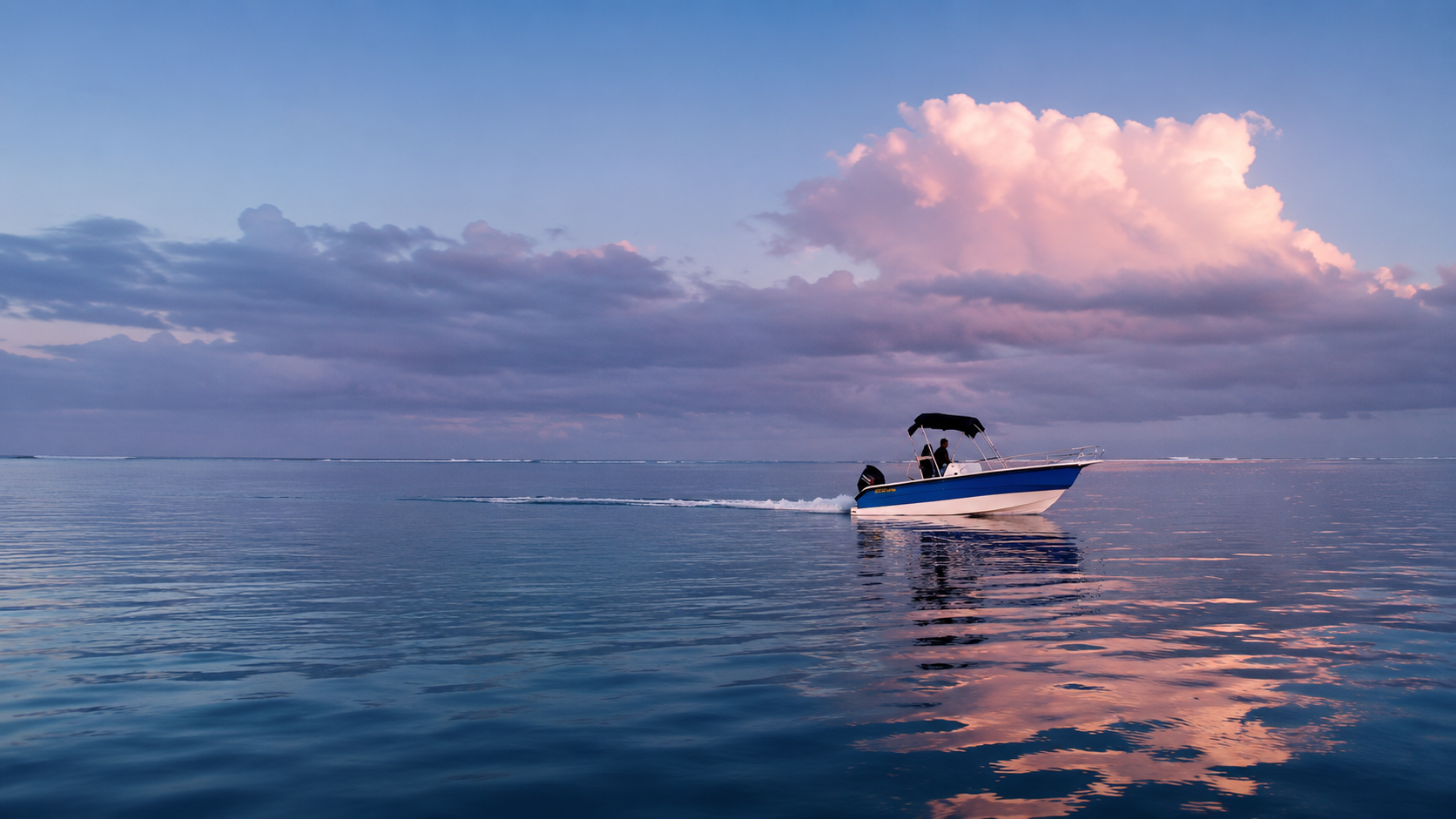 The Aqua Morne boat on flat water off Le Morne at first light