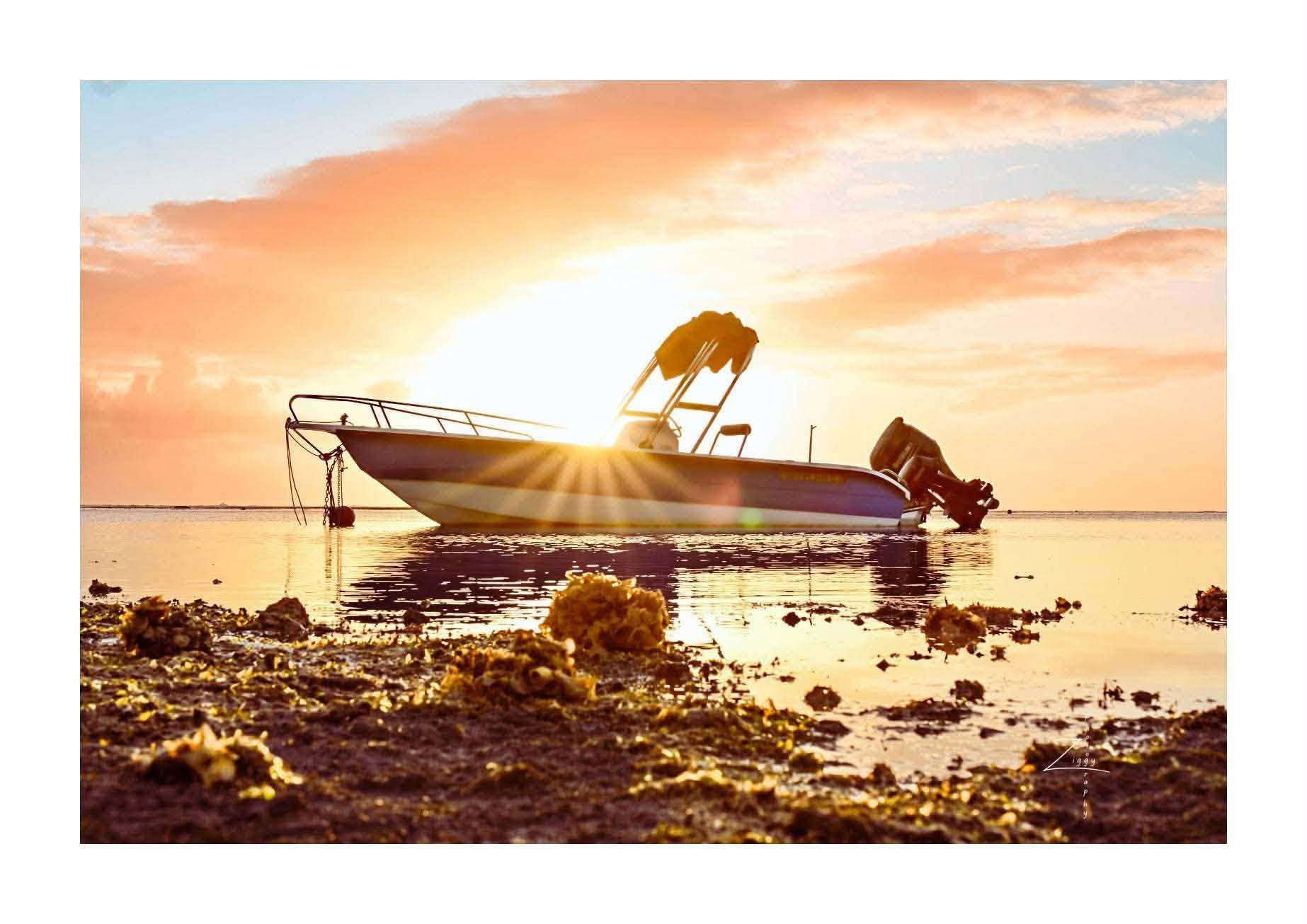The boat anchored in the turquoise lagoon